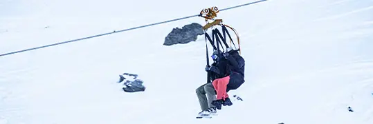 deux personnes qui utilisent les remontées mécaniques d'une station de ski
