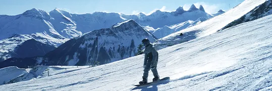 Une personne qui dévale une piste de ski en snoxboard