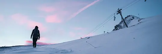 une personne qui remonte la piste de ski à pieds