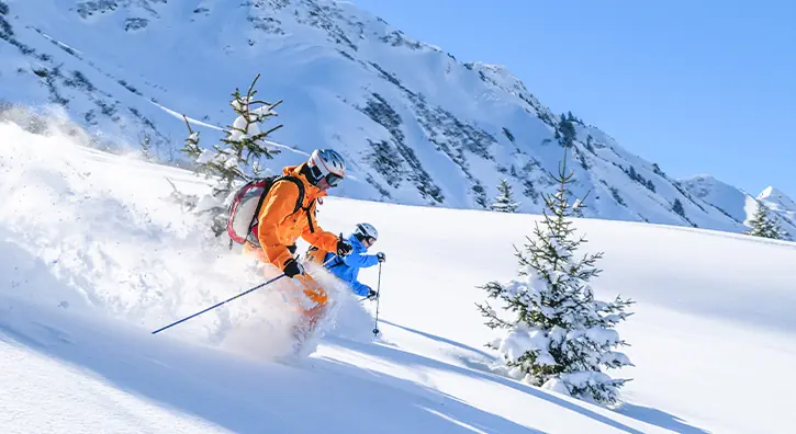 Deux skieurs qui dévalent une piste