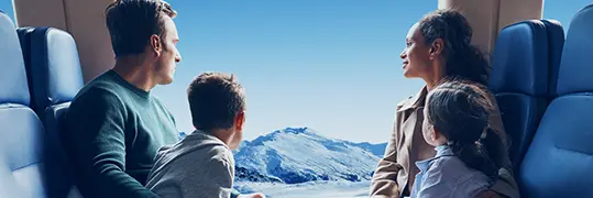 Une famille qui admire la vue d'un paysage montagneux depuis un train